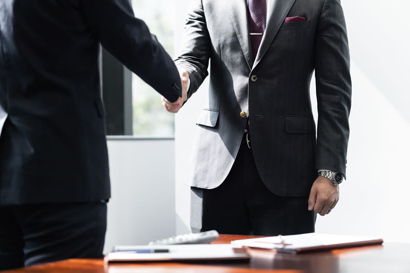 Two business people shaking hands on a UK business sale